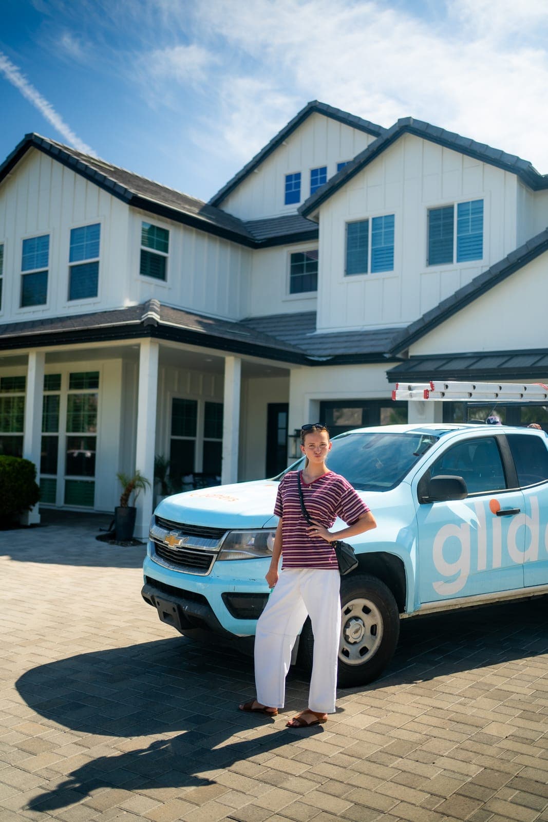 Glide service truck parked in front of a two-story home with large windows